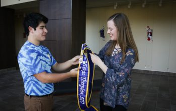 Nick Marquez passing the state thespian officer sash on to Christina Julian